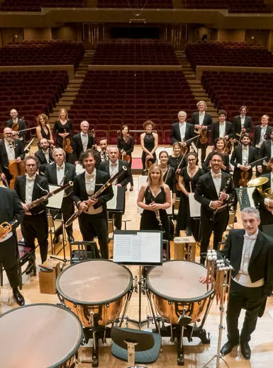 Orchestra sinfonica in abito da sera posa nella sala concerti – eventi culturali a Merano